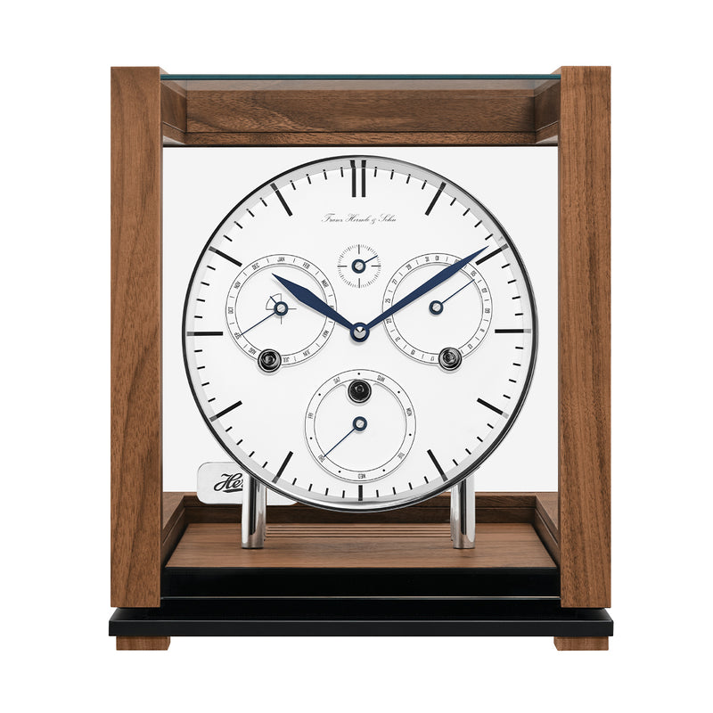 Front view of walnut perpetual calendar clock with silver highlights and glass panels on white background.