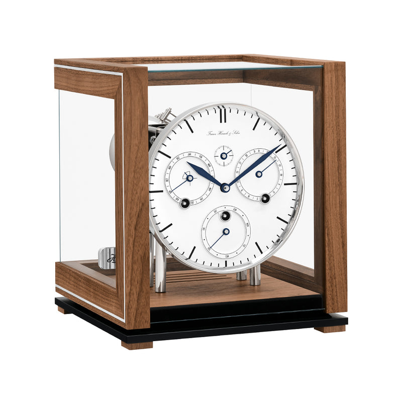 Walnut perpetual calendar clock with white face, silver highlights and glass panels on white background.