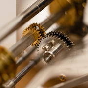 Close up of nickel and brass gears in mechanical clock.