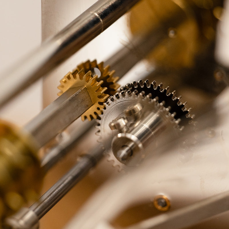 Close up of nickel and brass gears in mechanical clock.