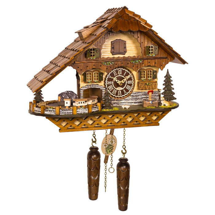 Detailed wooden cuckoo clock with house design and small train on one side, with roman numeral face and Made In Germany marking
