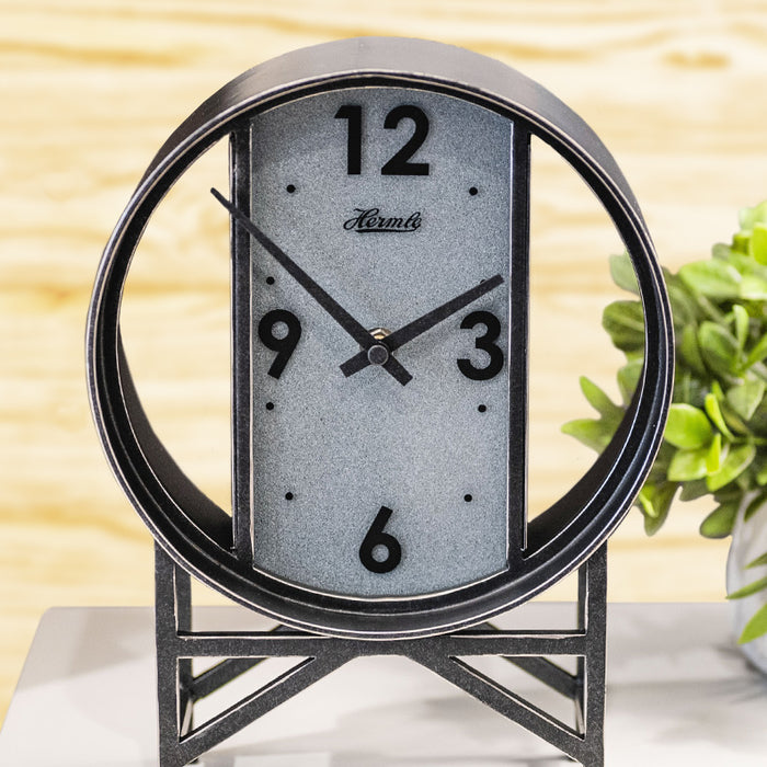 Decorative metal table clock with a circular design on a light background