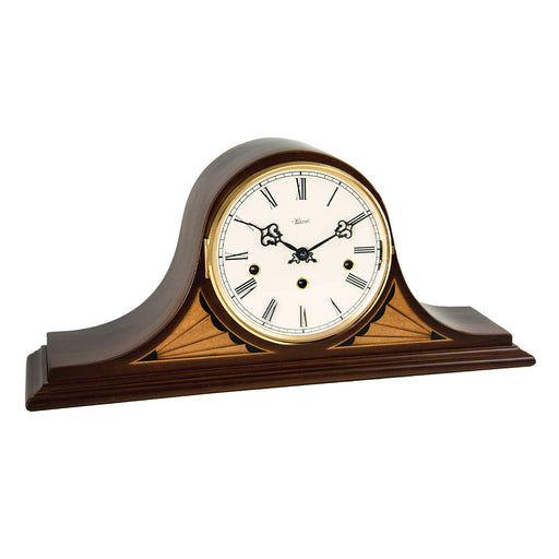 Vintage style tambour mantel clock with brass ring around the dial and roman numerals on white background.