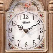 Close up of illustrated clock face with moon dial on wooden clock. 