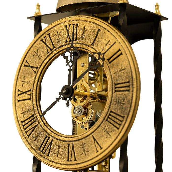 Close up of antique-style brass clock face and gears on white background.