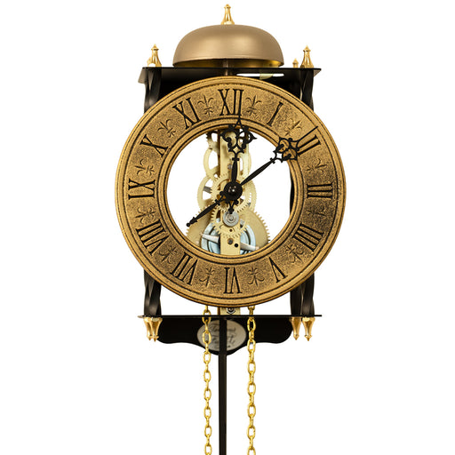 Skeleton clock with antique-style brass face and etched roman numerals on white background.