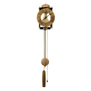 Skeleton clock with antique-style brass face and etched roman numerals on white background with brass chains and single weight hanging down.