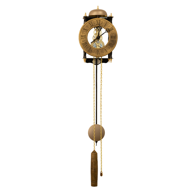 Skeleton clock with antique-style brass face and etched roman numerals on white background with brass chains and single weight hanging down.