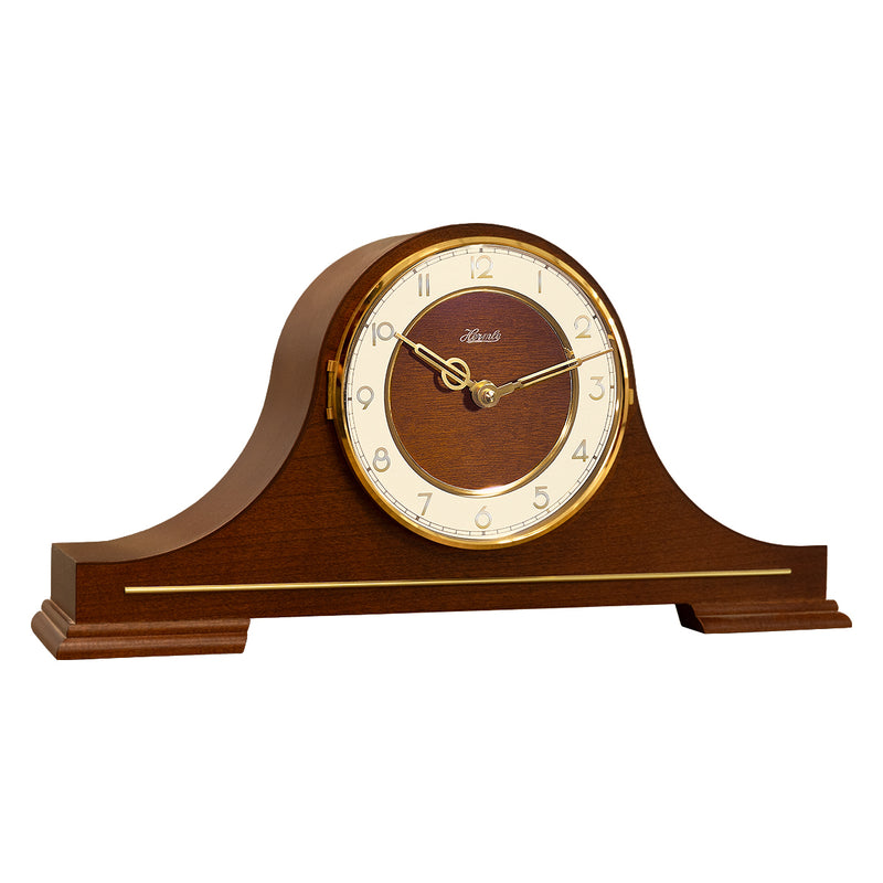 Wood and brass mantel clock with Hermle logo and brass arabic numerals on white background.