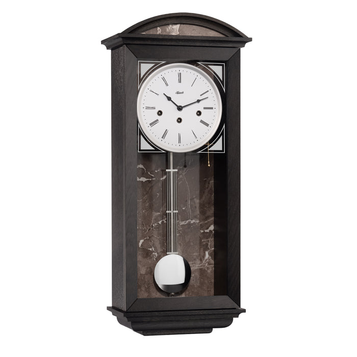 Black wood wall clock with nickel pendulum and three holes in the face for winding the mechanical movement inside.