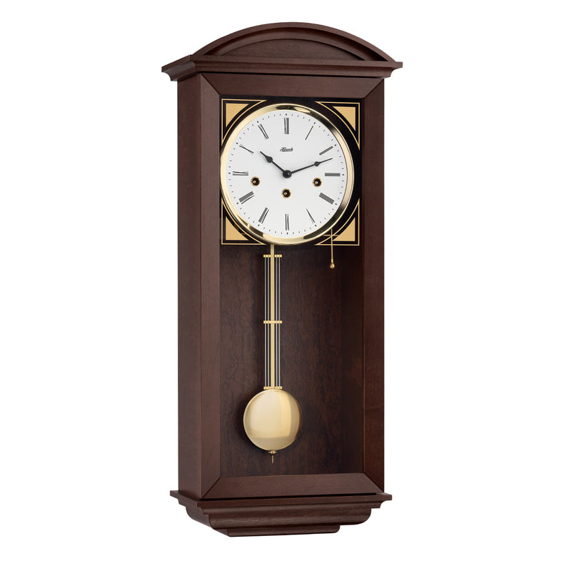 walnut wood wall clock with brass pendulum and three holes in the face for winding the mechanical movement inside.