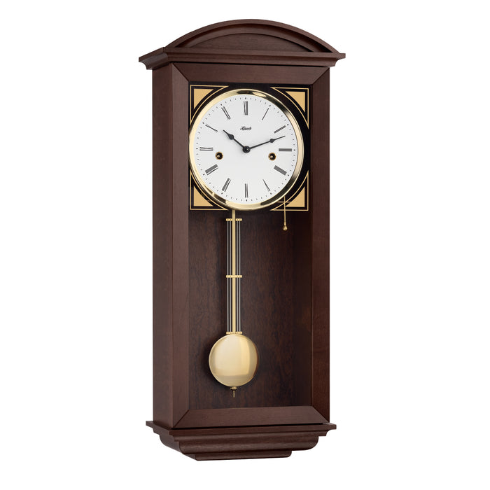 walnut wood wall clock with brass pendulum and two holes in the face for winding the mechanical movement inside.