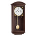walnut wood wall clock with brass pendulum and two holes in the face for winding the mechanical movement inside.