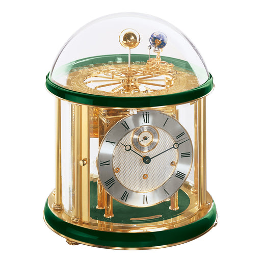Green and brass Tellurium clock with glass dome and brass plated mechanical gears visible on white background.