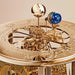 Gold mechanical clock gears with intricate design and globe on a beige background.