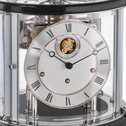 Up close of Tellurium clock face with silver color and roman numerals behind nickel framed glass.