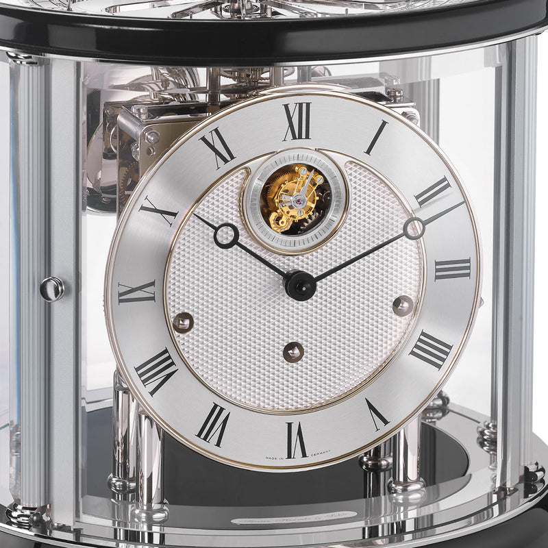 Up close of Tellurium clock face with silver color and roman numerals behind nickel framed glass.