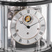 Up close of Tellurium clock face with silver color and roman numerals behind nickel framed glass.