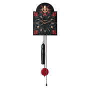 Black Wall clock with decorative red designs and red pendulum on white background.