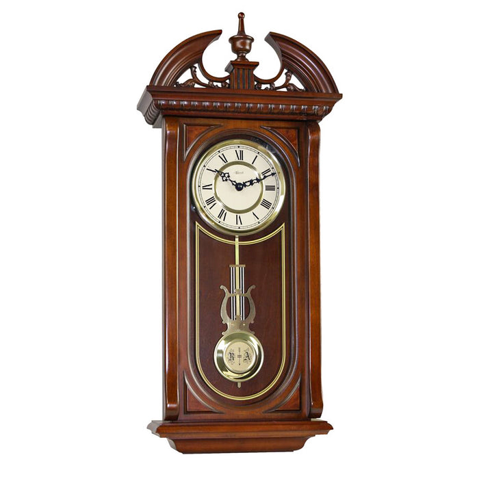 ornate wooden wall clock with brass highlights and pendulum on white background