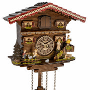 Close-up of chalet style cuckoo clock with family on white background