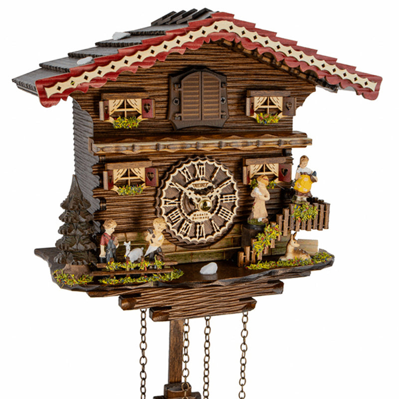 Close-up of chalet style cuckoo clock with family on white background