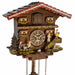 Close-up of chalet style cuckoo clock with family on white background
