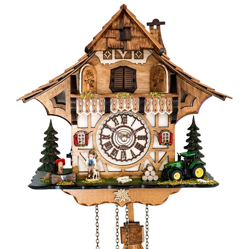 Up close of detailed cuckoo clock with wooden face, tractor and boy figure 