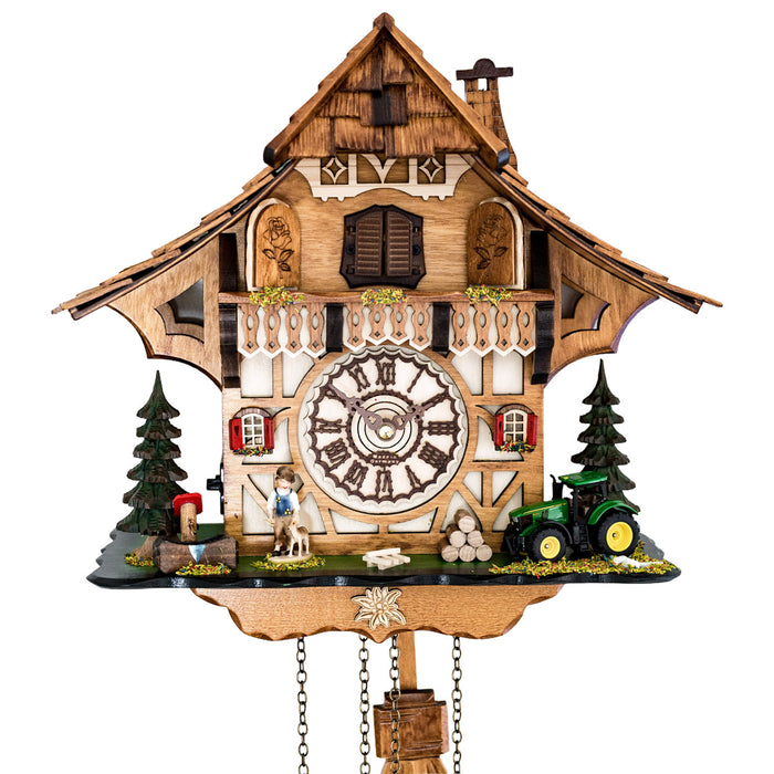 Up close of detailed cuckoo clock with wooden face, tractor and boy figure 