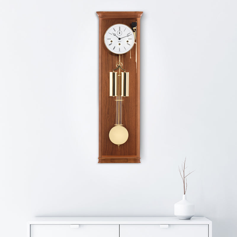 Light Cherry wood regulator wall clock hanging on white wall above white dresser