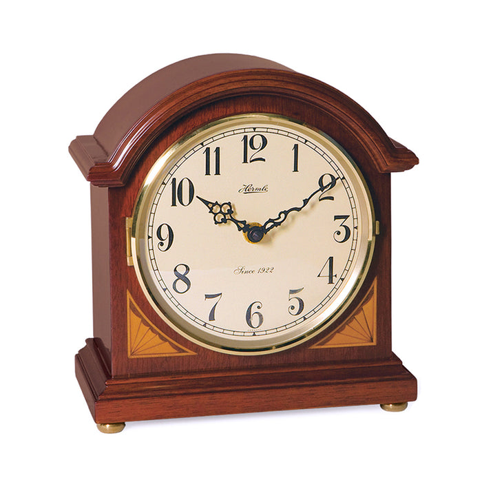 Cherry wood barrister mantel clock with brass highlights on white background.