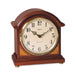 Cherry wood barrister mantel clock with brass highlights on white background.