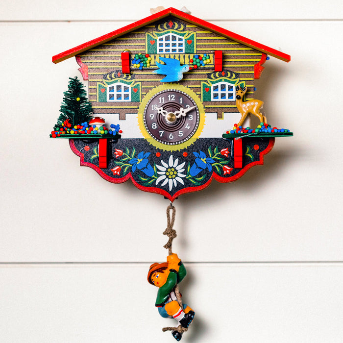 Decorative cuckoo clock with colorful design hanging on white wall