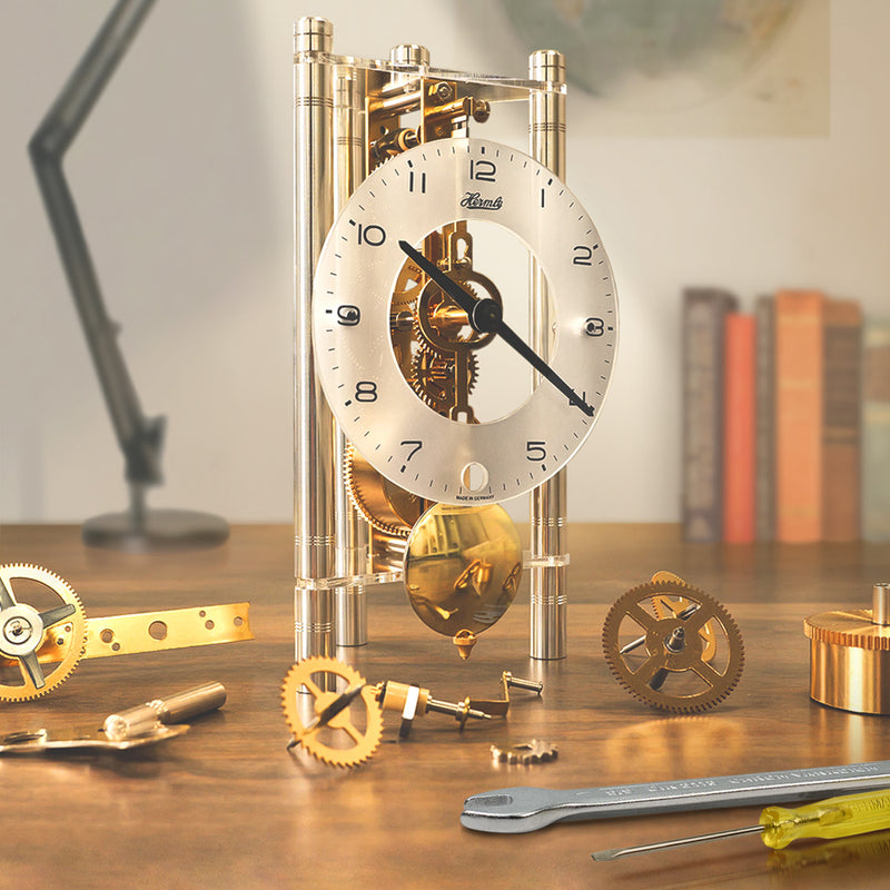 Mechanical Lakin clock kit with gears and tools on a wooden desk